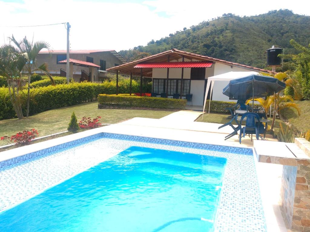 a swimming pool in front of a house at Casa de campo San Fernando in Villeta