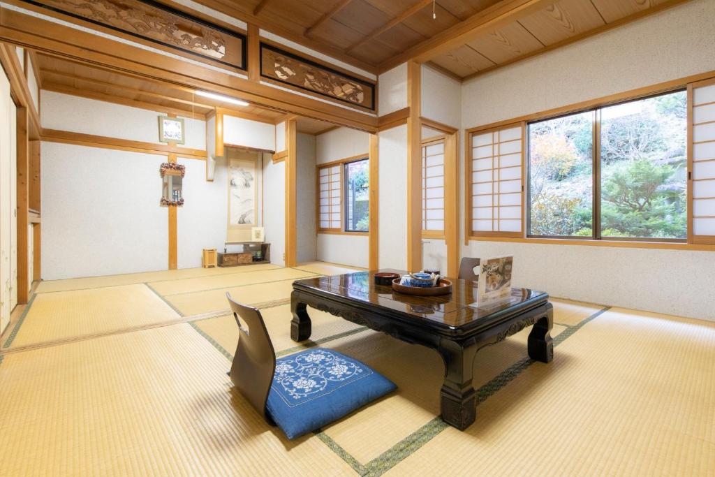 ein Wohnzimmer mit einem Tisch und einem Stuhl in der Unterkunft Ichimaru Ryokan - Vacation STAY 59281v in Tenkawa