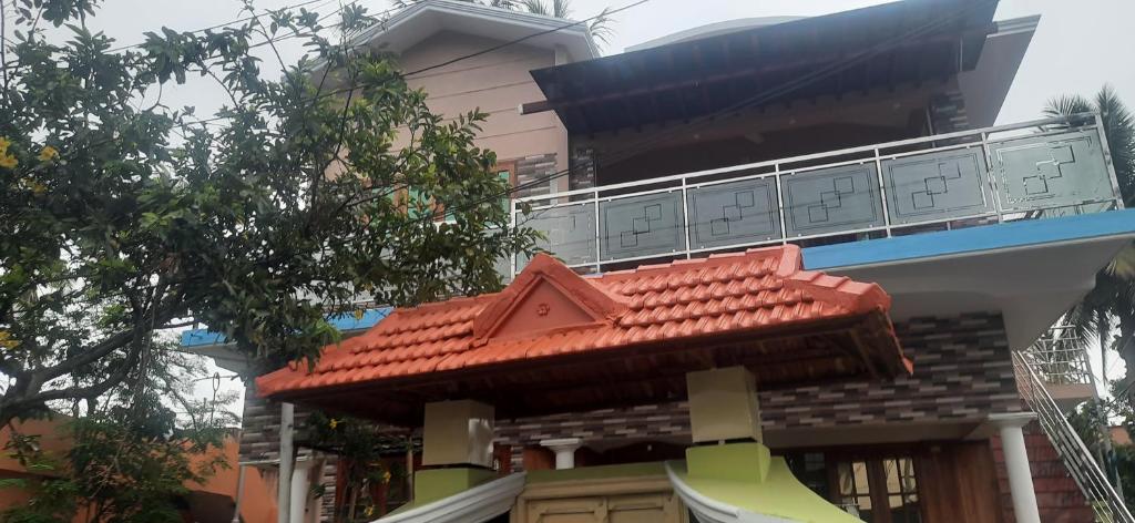 un edificio con techo rojo y balcón en Texas Guest house en Thiruvananthapuram