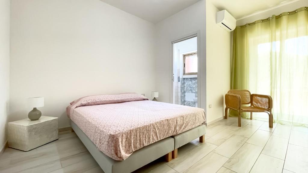 sypialnia z łóżkiem, krzesłem i oknem w obiekcie Orlamare w Agropoli