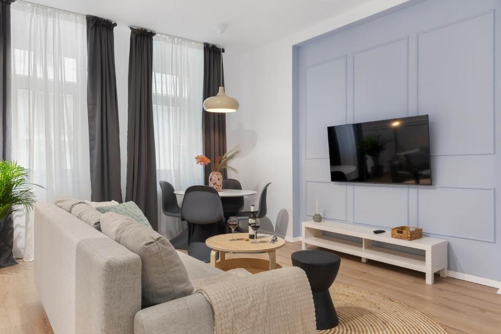 a white living room with a couch and a tv at VD Boutique Apartments No 2 in Bucharest