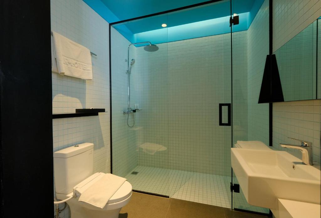 a bathroom with a shower and a toilet and a sink at ARTOTEL Gajahmada Semarang in Semarang