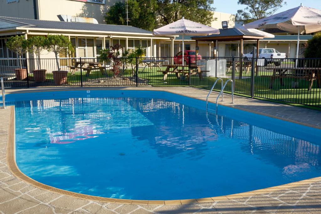 una grande piscina blu di fronte a un edificio di Ashwood Motel a Gosford