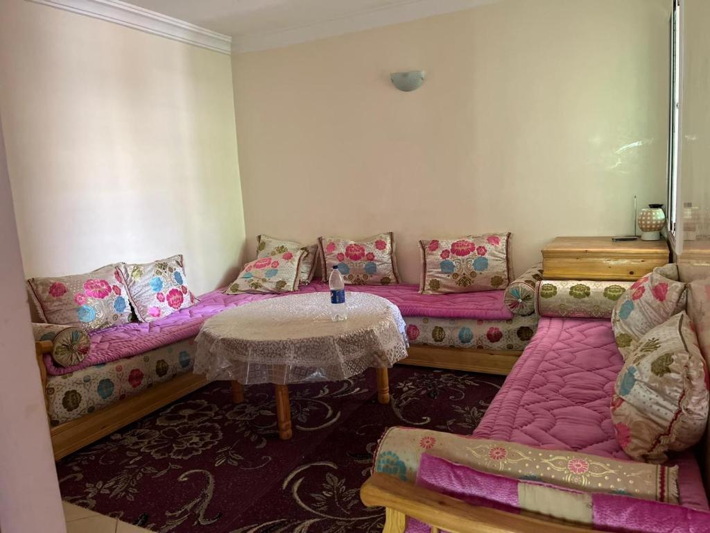 Cette chambre comprend un canapé, une table et des chaises. dans l'établissement Oum Khaltoum Martil, à Martil
