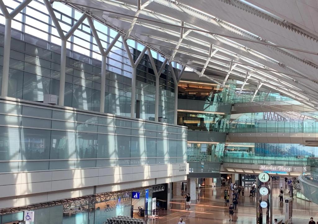 a large glass building with people walking in it at APA Hotel Haneda Anamori Inari Ekimae in Tokyo