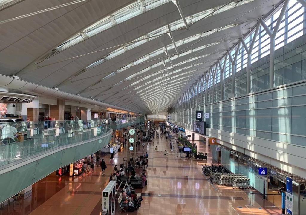 a large airport with people walking through a large building at APA Hotel Haneda Anamori Inari Ekimae in Tokyo