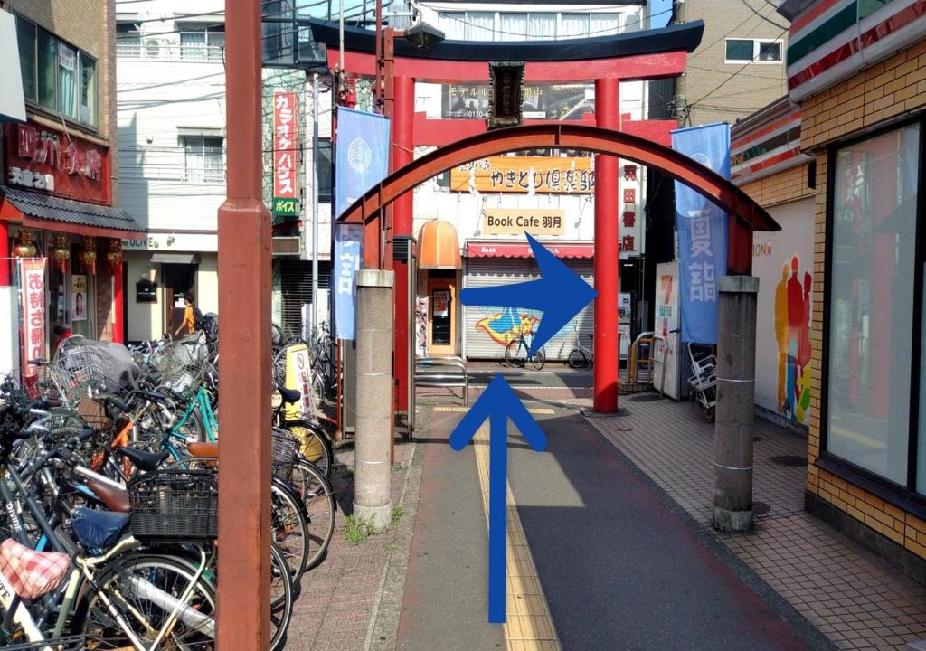 an arch with a blue arrow on a city street at APA Hotel Haneda Anamori Inari Ekimae in Tokyo