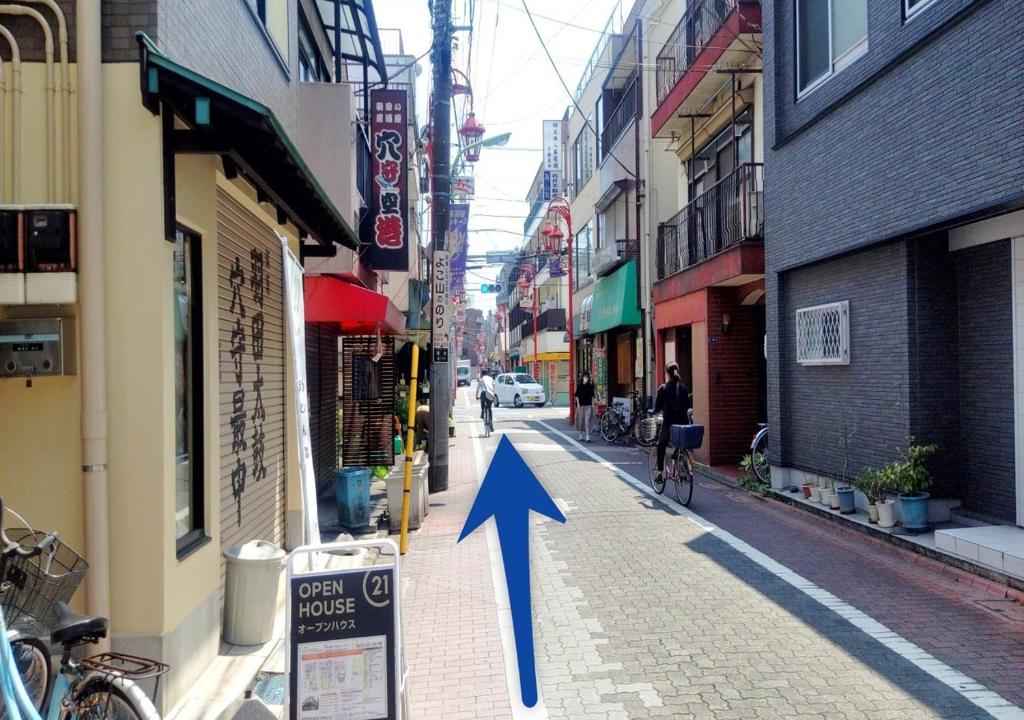 a blue arrow pointing down a city street at APA Hotel Haneda Anamori Inari Ekimae in Tokyo