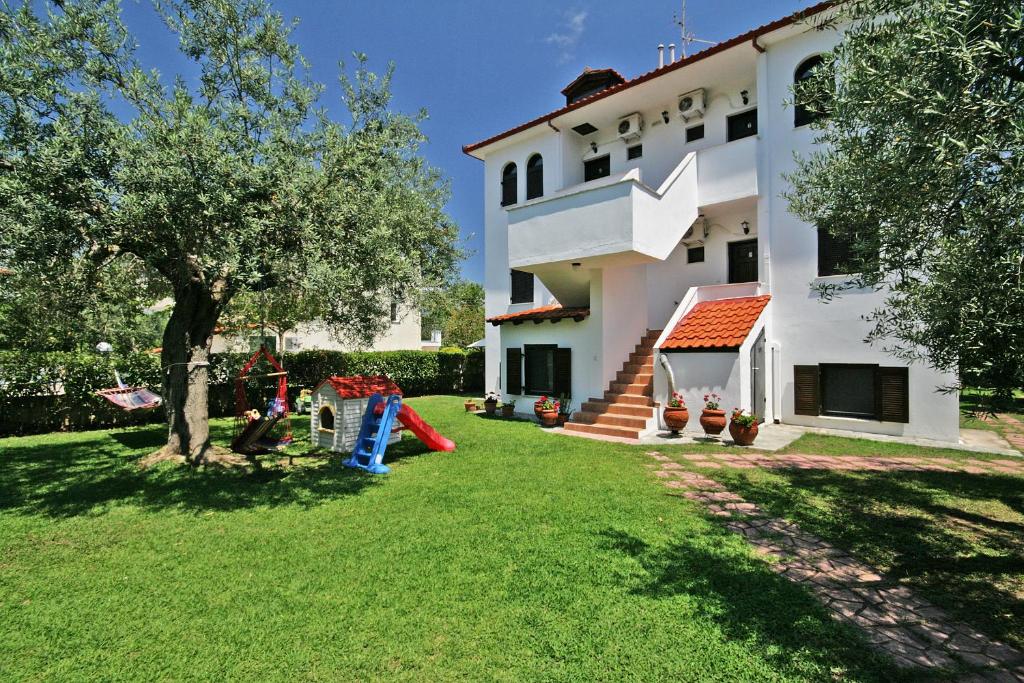 a house with a playground in the yard at Ioannis Appartamenti in Vourvourou