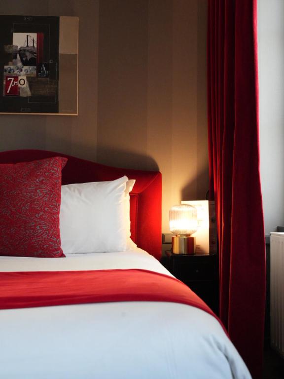 - une chambre avec un lit rouge et un rideau rouge dans l'établissement Alexandra, à Lyon