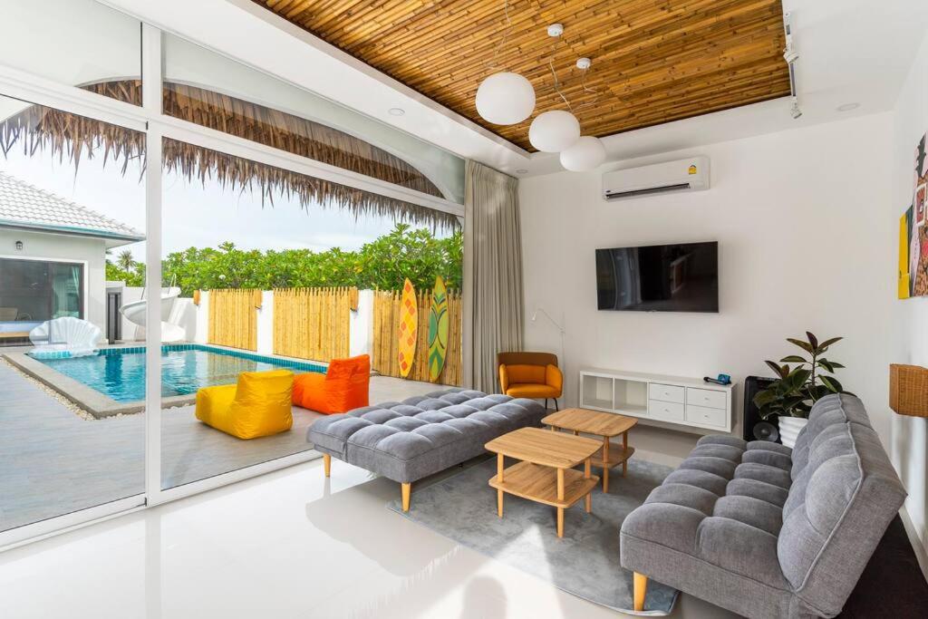 a living room with a couch and a table and a pool at HuaHin◆PaiMai PoolVilla◆4BR◆Karaoke by น้องมังคุด in Hua Hin