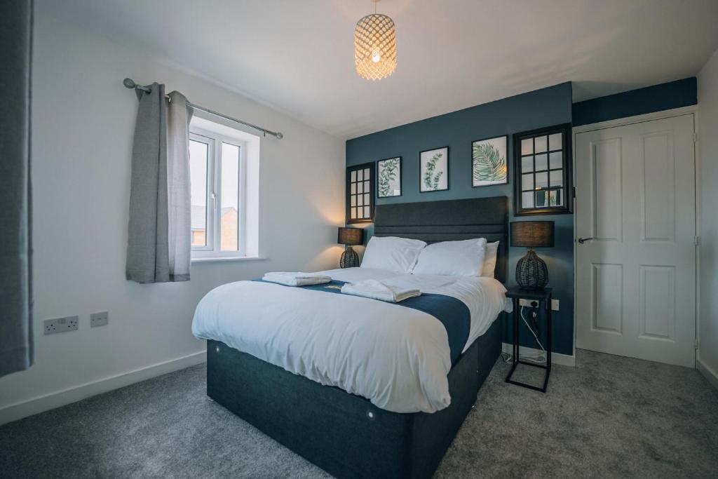 una camera da letto con un grande letto con pareti blu di Mersey House By Horizon Stays a Redcar