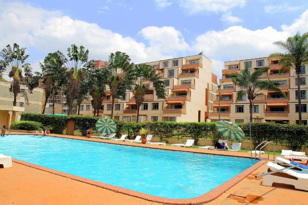 a large swimming pool in front of a building at Norfolk Towers Serviced Apartment -Nairobi, City Centre CBD in Nairobi