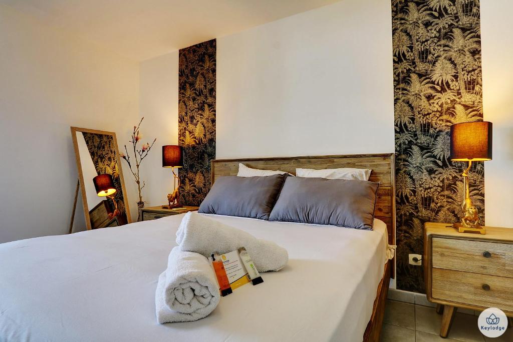 - une chambre avec un lit blanc et des serviettes dans l'établissement La Tonnelle - 42m2 - Terrasse - Sainte-Clotilde, à Saint-Denis
