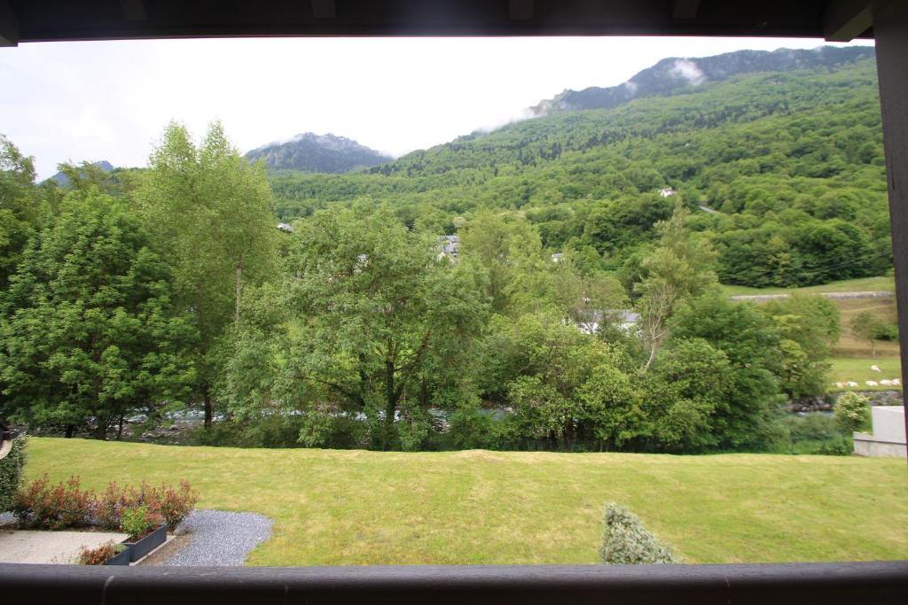 uma vista para um campo verde com árvores e montanhas em CG APPART**4 PERS VUE GAVE BALCON 5 MN LUZ em Luz-Saint-Sauveur