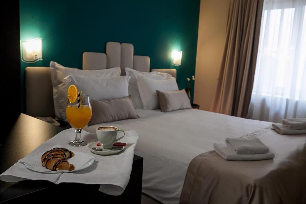 a hotel room with a bed with a drink and a plate of food at Boutique Hotel Bura 45N in Senj