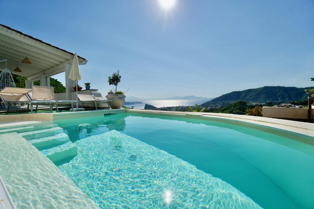 a swimming pool with blue water in a house at Relais Villa Ettore in Ischia