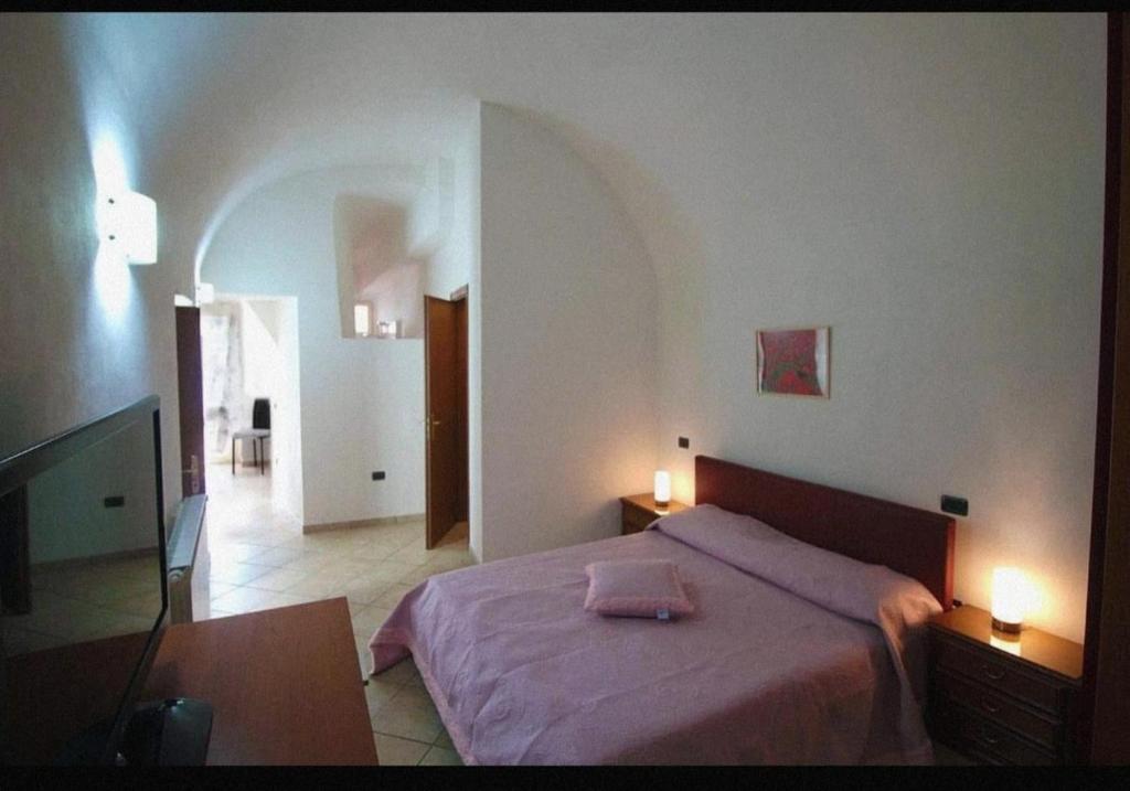 a bedroom with a bed with two lights on it at B&B LA CASETTA DI ALICE in Cascia