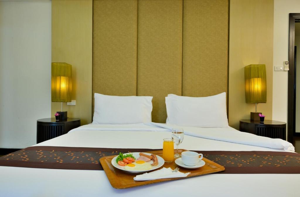 A twin-bed sleeping area styled with bedside lamps and a breakfast tray.