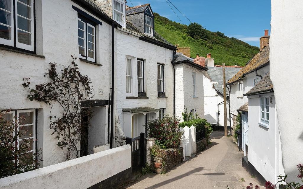 艾薩克港的住宿－Brakestone Cottage in the heart of Port Isaac，白色房屋小镇的小巷