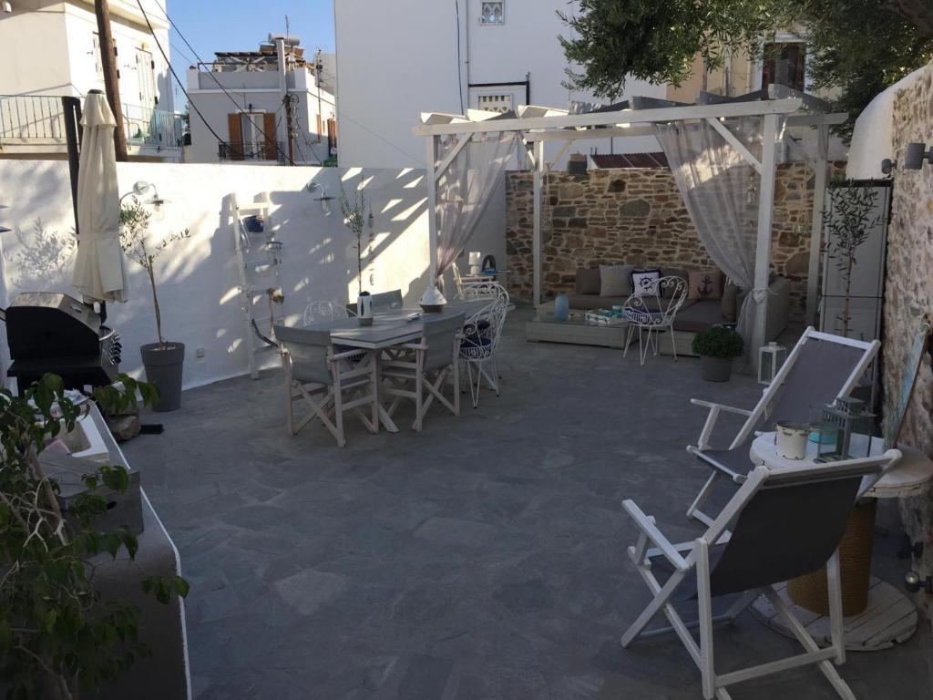 a patio with chairs and a table and a table and chairs at Cozy house with relaxing backyard in Ermoupoli
