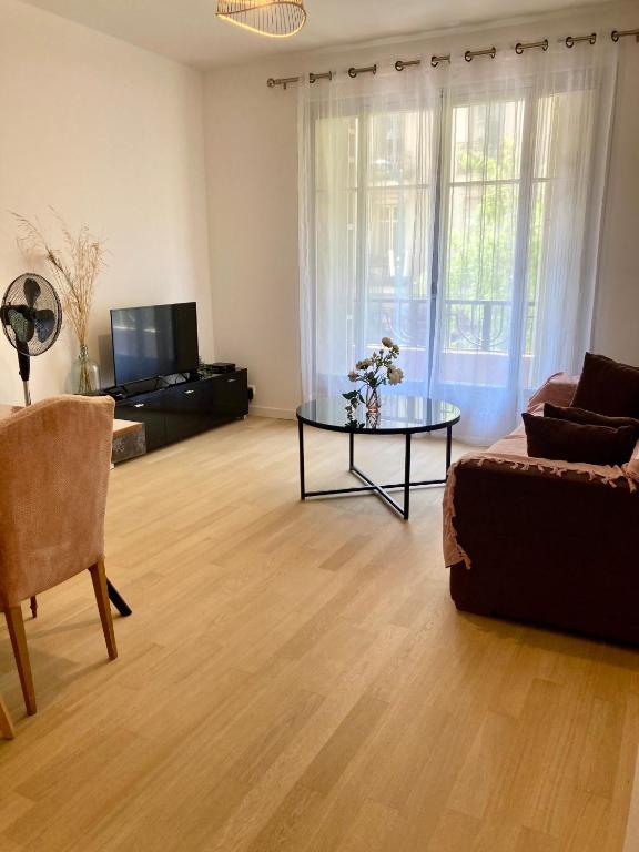 un salon avec un canapé et une table en verre dans l'établissement Edouard VII, à Menton