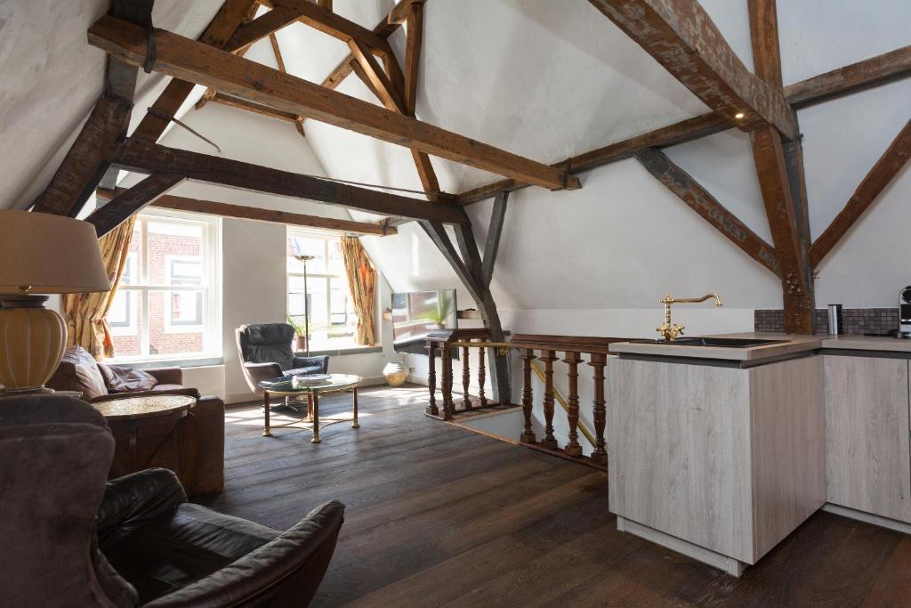 una sala de estar con techos de madera y suelo de madera. en The Loft 300 - R Q C, en La Haya