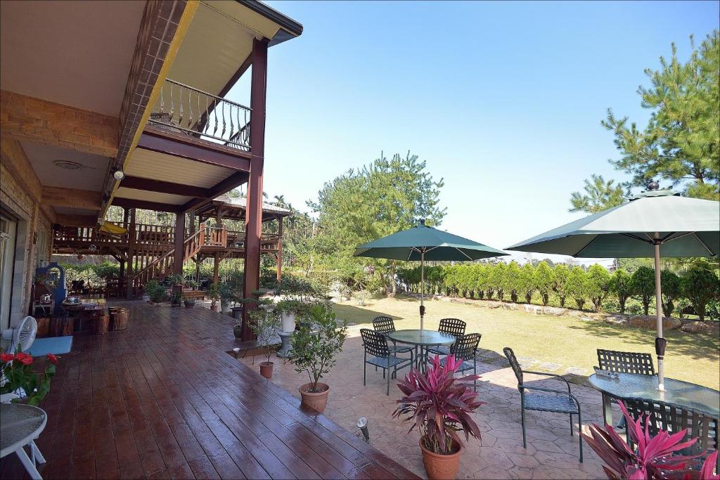 an outdoor patio with tables and chairs and umbrellas at Sitou Peach Villa B&amp;B in Lugu Lake