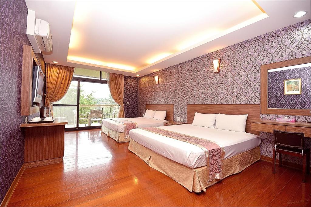 a hotel room with two beds and a television at Sitou Peach Villa B&amp;B in Lugu Lake