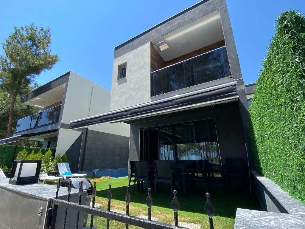 ein modernes Haus mit einem Zaun davor in der Unterkunft Özel havuzlu lüks villa in Kusadası