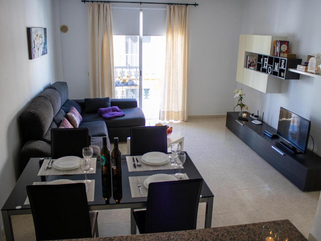 een woonkamer met een bank en een tafel bij Puesta de Sol Rentals 3DR in Playa de San Juan