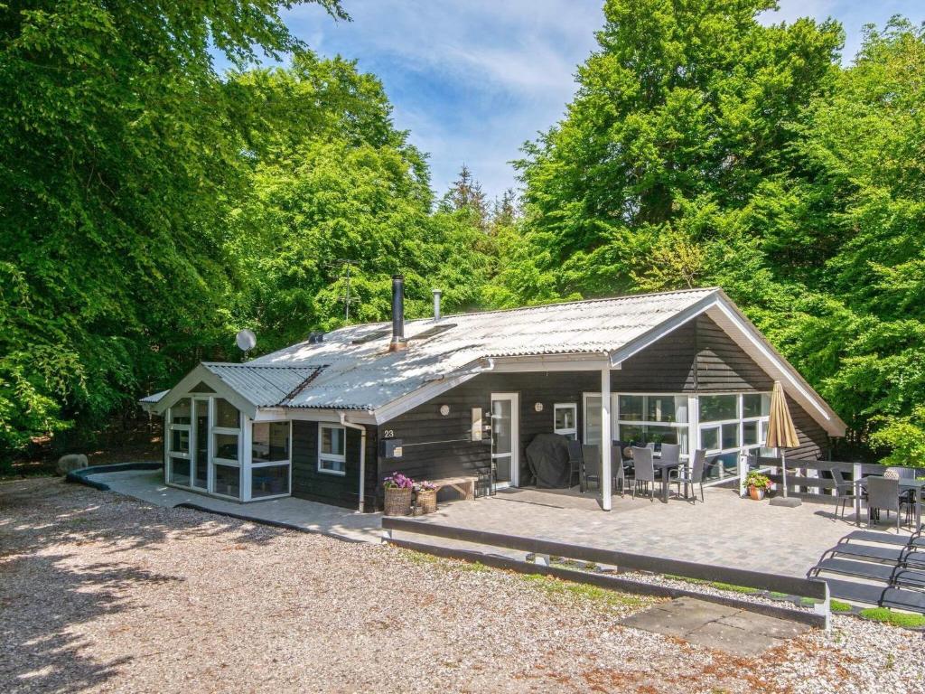 a small cabin with a porch in the woods at 12 person holiday home in Glesborg in Glesborg