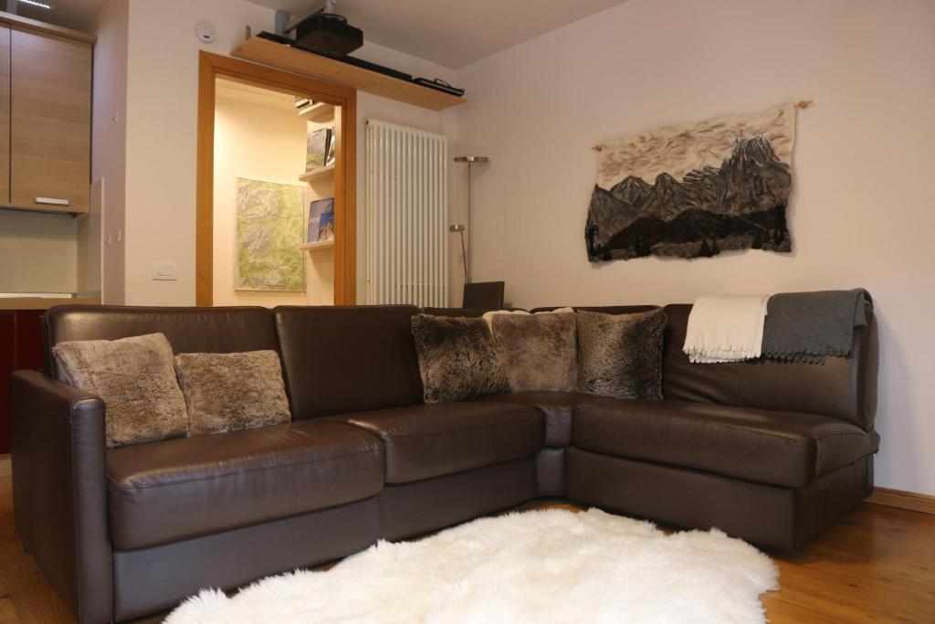 un sofá de cuero marrón en la sala de estar en Italian Apartment with Hot Tub, en Arabba
