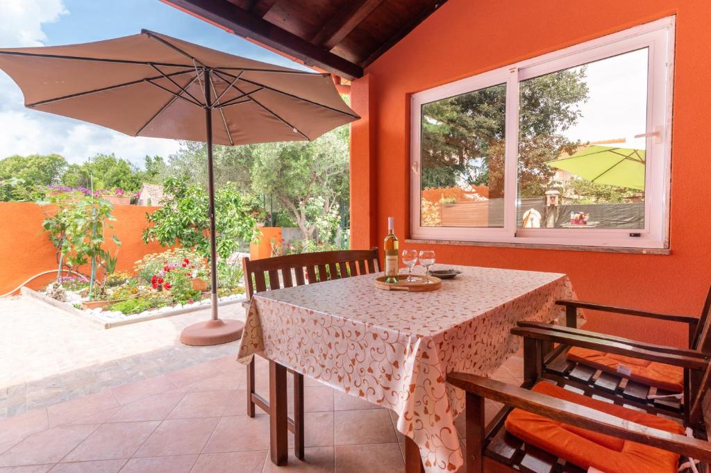 ein Esszimmer mit einem Tisch und einem Sonnenschirm in der Unterkunft House Suzi in Zadar