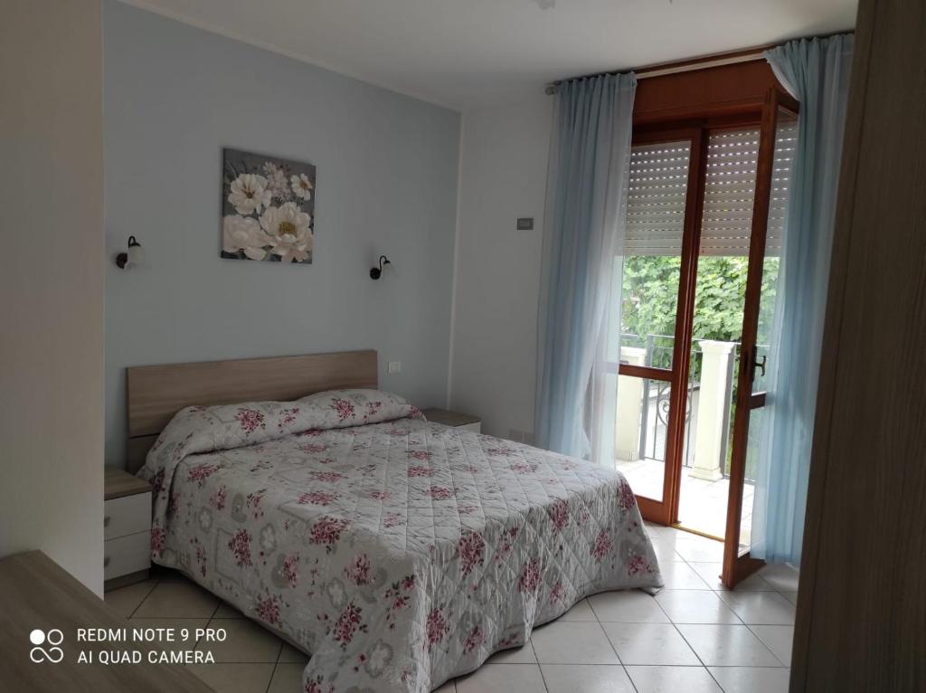 um quarto com uma cama e uma porta de vidro deslizante em APPARTAMENTI RIMINI NEL CUORE em Rimini