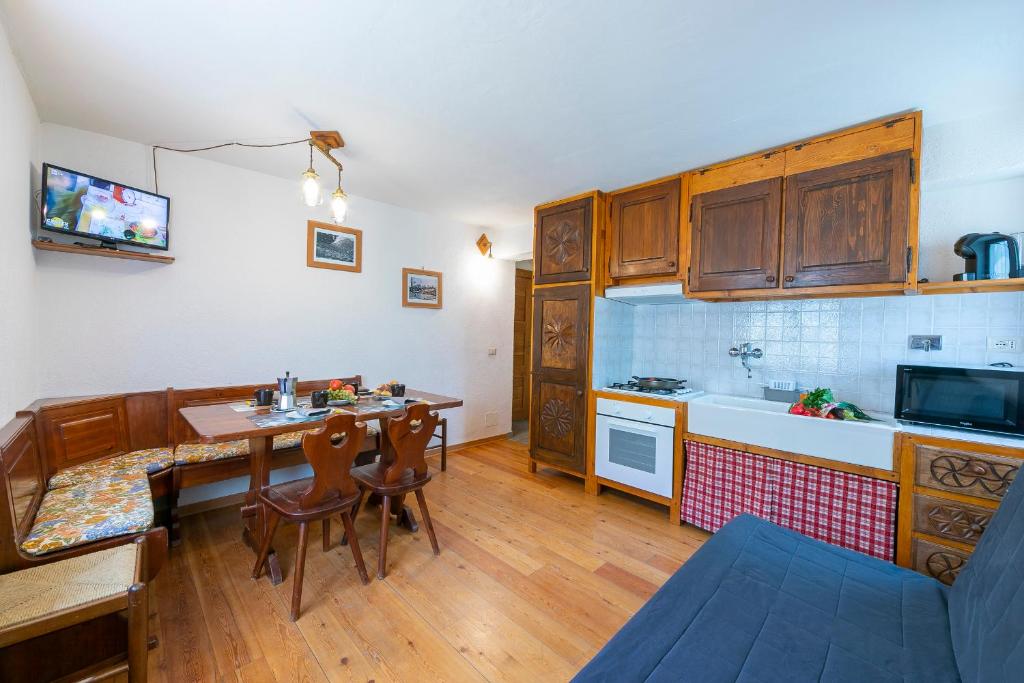 a kitchen with a table and a dining room at Miramonti 21 Ski In - Ski Out - Happy Rentals in Sauze dʼOulx