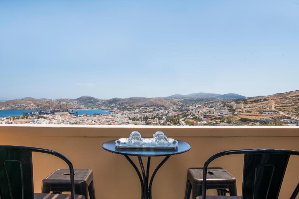 a table and chairs with a view of the city at Ano Siroa in Ano Syros