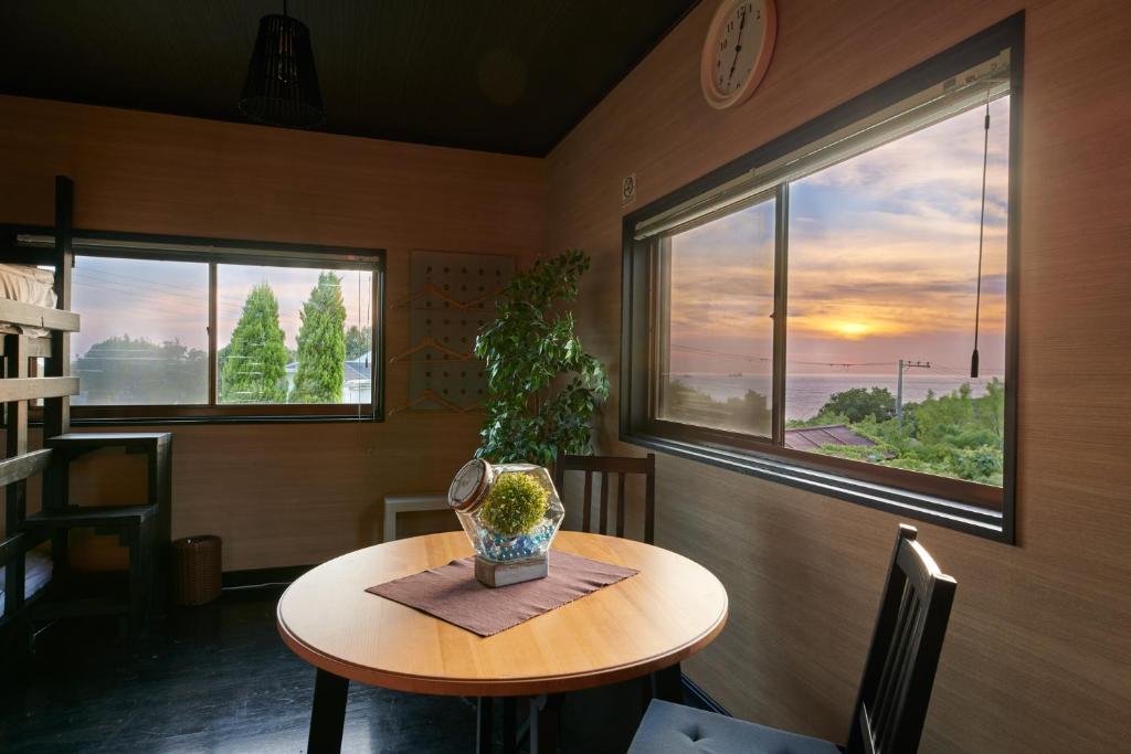 Awaji Aquamarine Resort #3 - Self Check-In Only في Awaji: غرفة مع طاولة عليها نبات