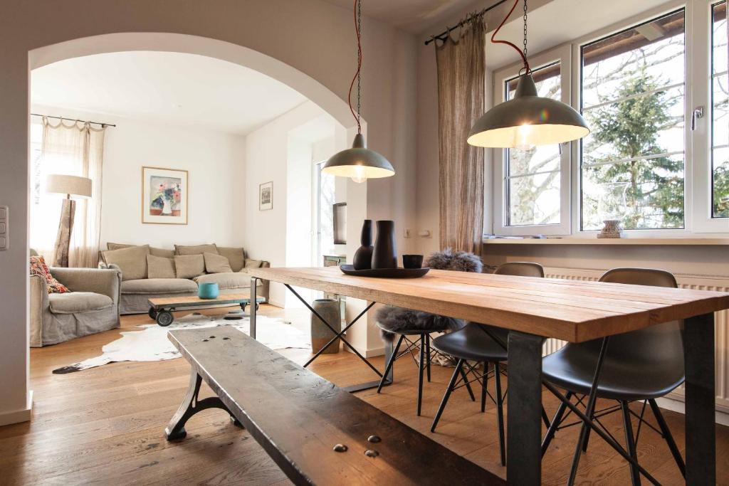 a living room with a large wooden table and chairs at Rustikales Studio mit Bergblick in Tegernsee