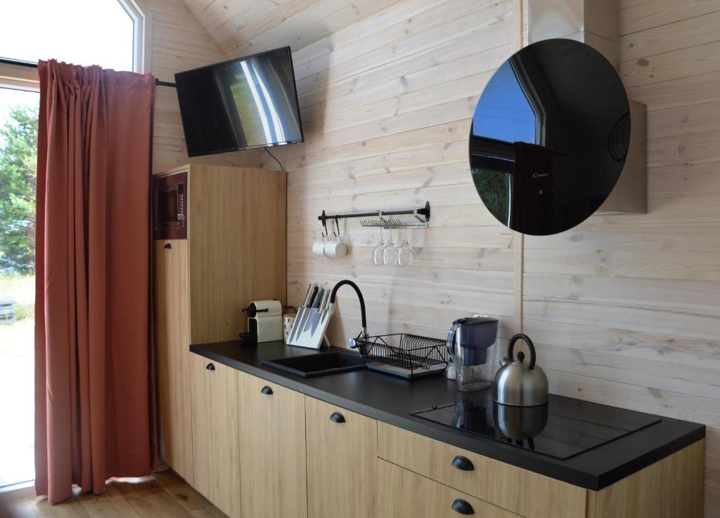 a kitchen with a sink and a mirror on the wall at Morska Szyszka & Leśne SPA in Odargowo