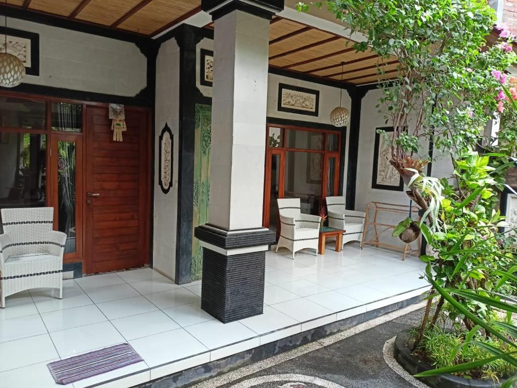 羅威那的住宿－Rumah Askara，房屋设有门廊、椅子和桌子