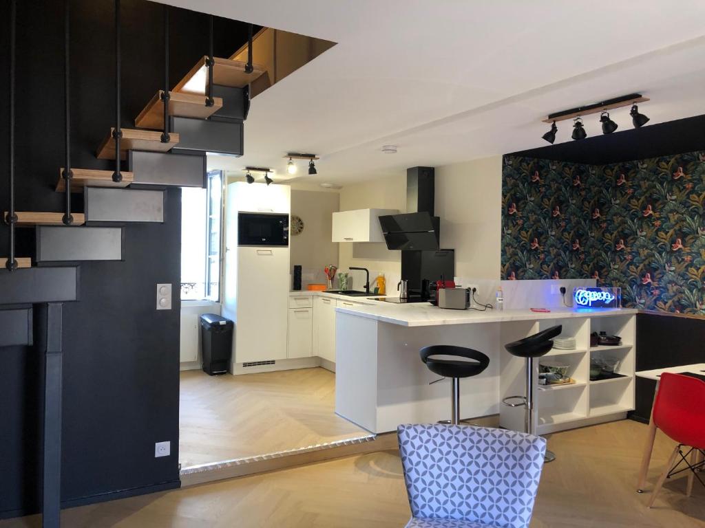 VUE SUR REMPARTS - Coeur de Vannes- 2CH في فان: مطبخ مع كونتر وكراسي في غرفة