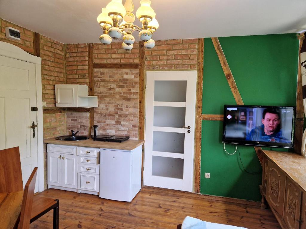 a kitchen with a tv on a green wall at TOBY 2 minuty do plaży nah am strand in Międzyzdroje