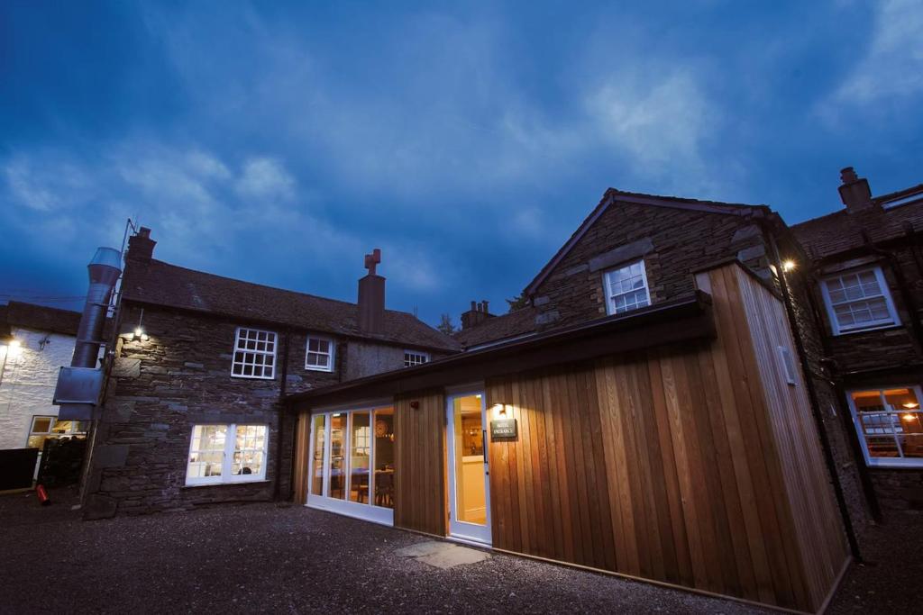 a contemporary house with a wooden facade at night at Royal Oak Hotel in Rosthwaite