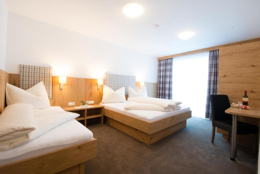 イシュグルにあるApart Stella Alpinaのベッド2台とデスクが備わるホテルルームです。