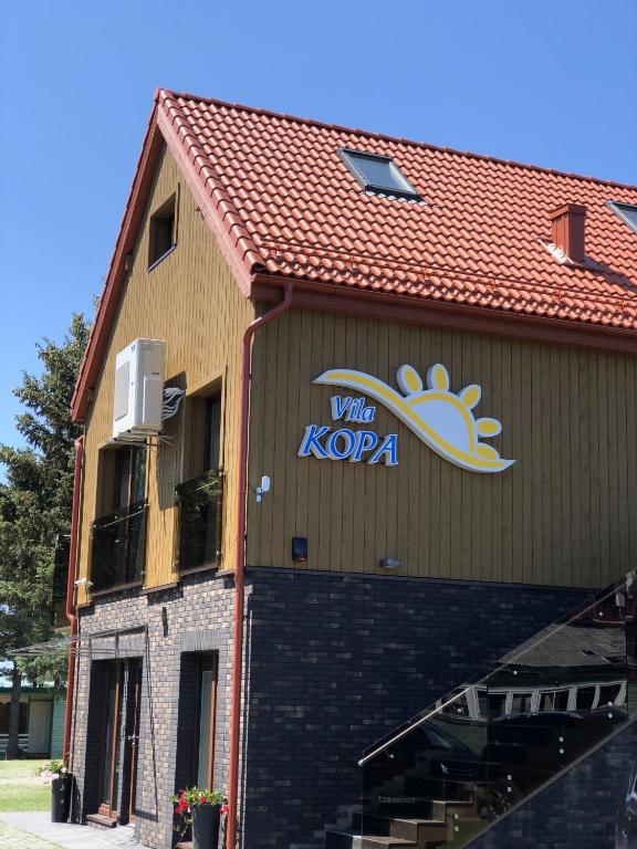 a building with a sign on the side of it at Vila KOPA Šventoji in Šventoji