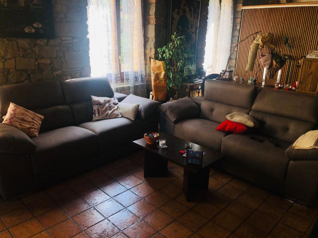 a living room with two couches and a table at Habitació polivalent al centre de Manresa in Manresa