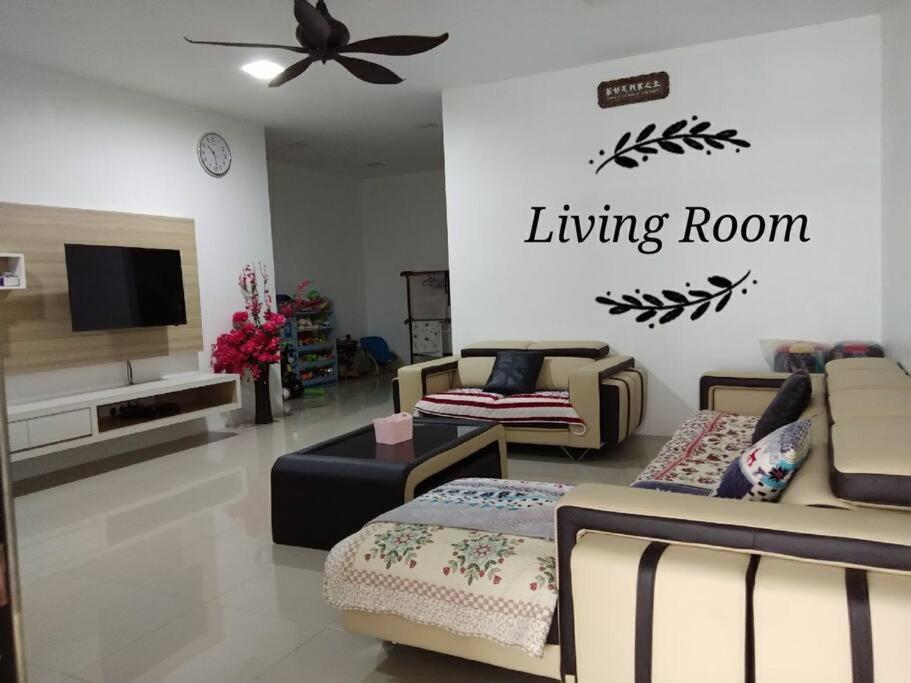 ein Wohnzimmer mit Sofas und einem Flachbild-TV in der Unterkunft Sakura Homestay 4 bedrooms 14pax- Eaton Hills Padang Kerbau Miri in Miri