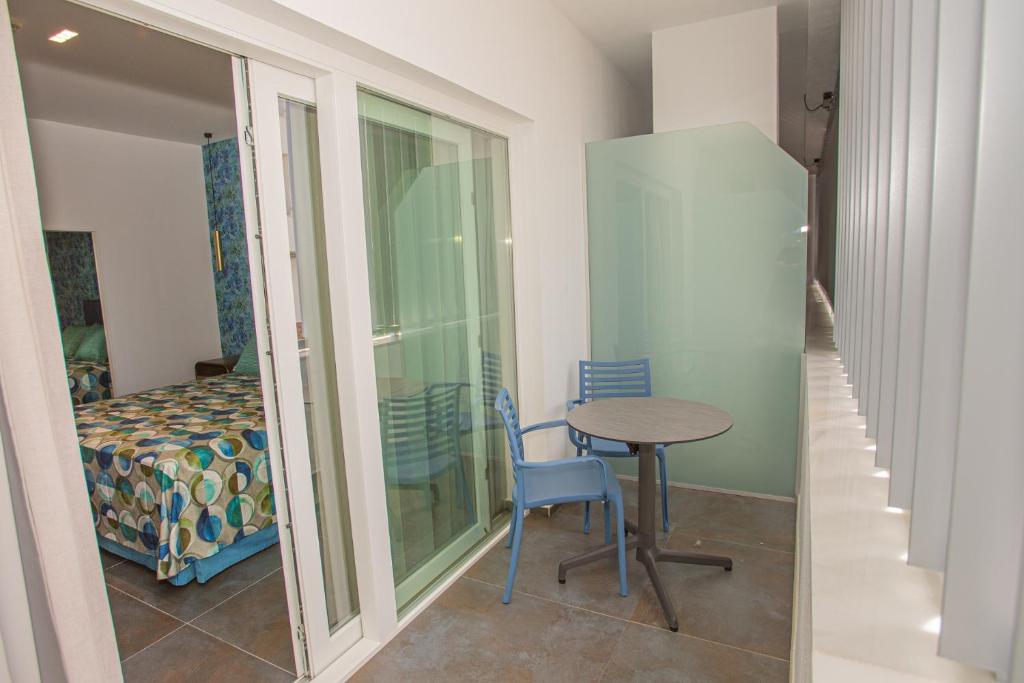 a small table and chairs in a room with a bedroom at Hotel Adiafa in Barbate