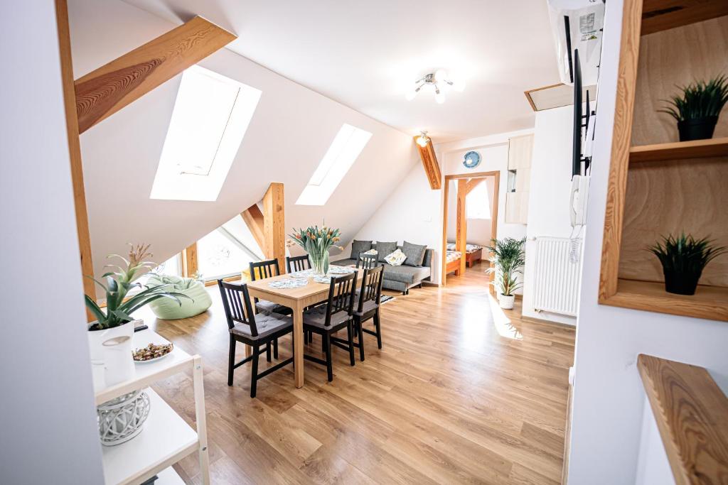 a dining room and living room with a table and chairs at Apartament Pastorówka in Pisz